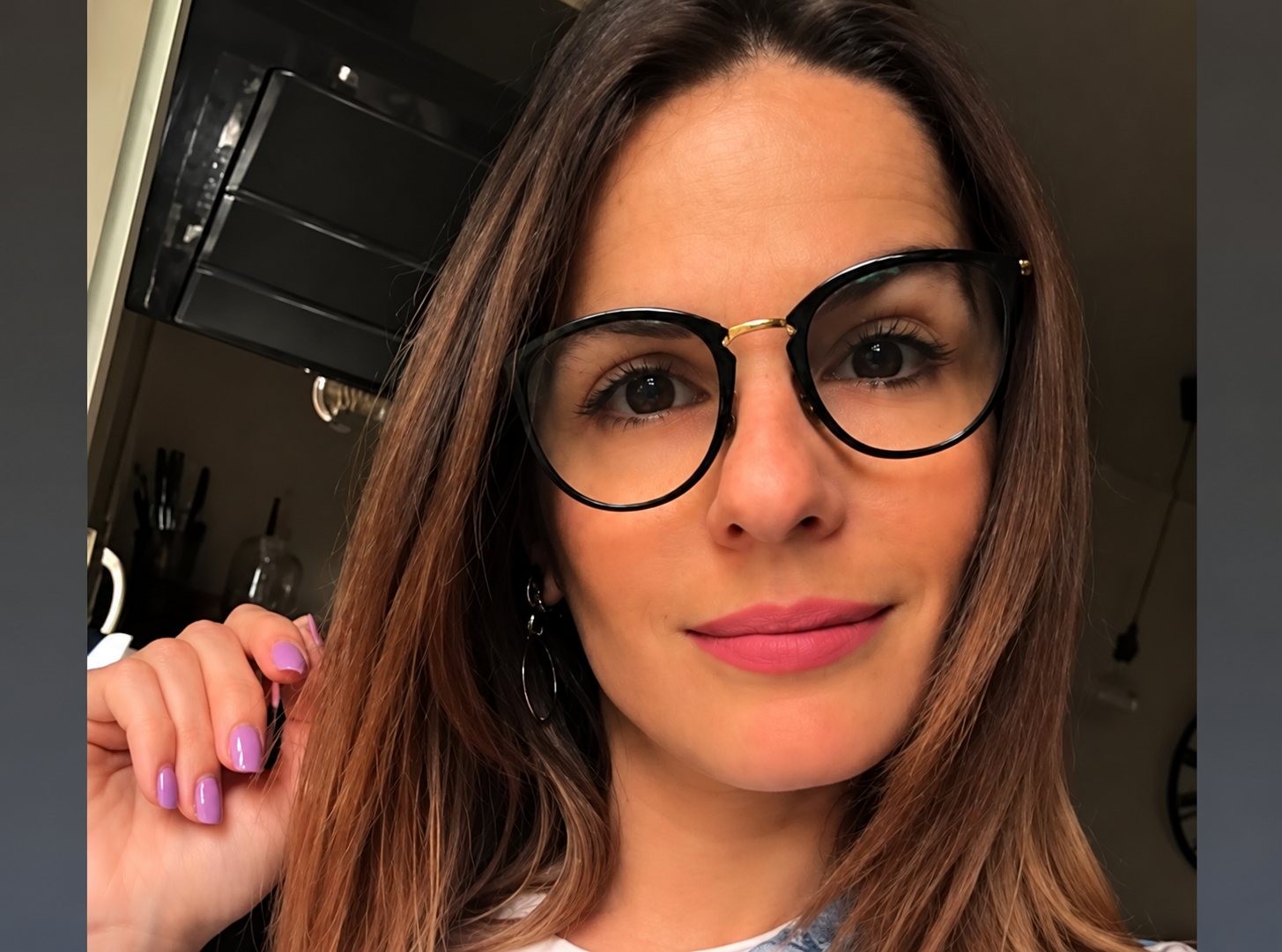 Portrait d'une femme souriante portant des lunettes rondes noires